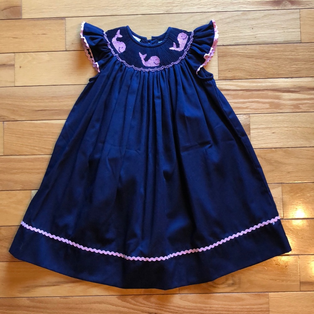 Navy smocked dress with pink whales and piping.